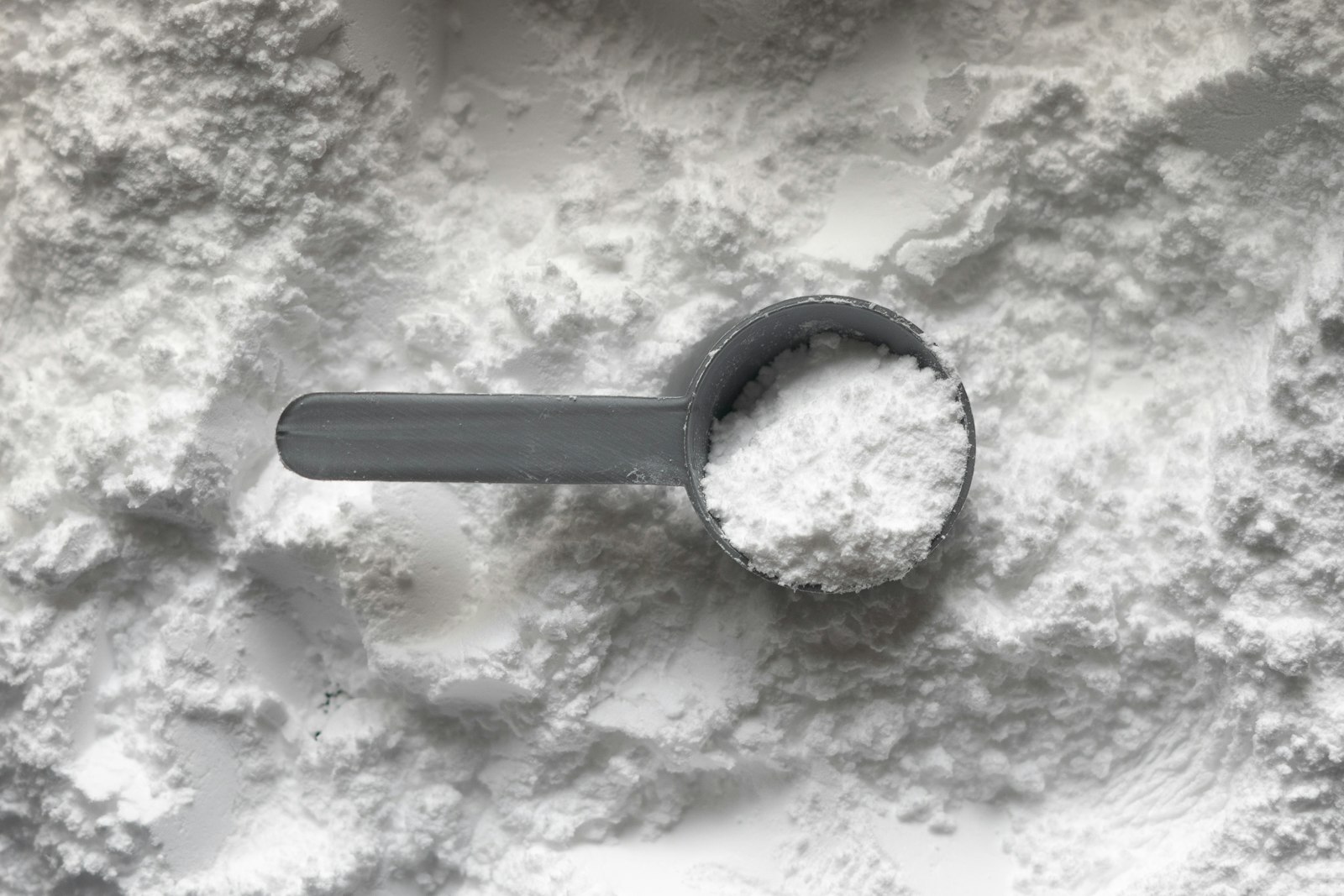 Messlöffel mit Kollagenpulver auf einem Pulverhaufen
